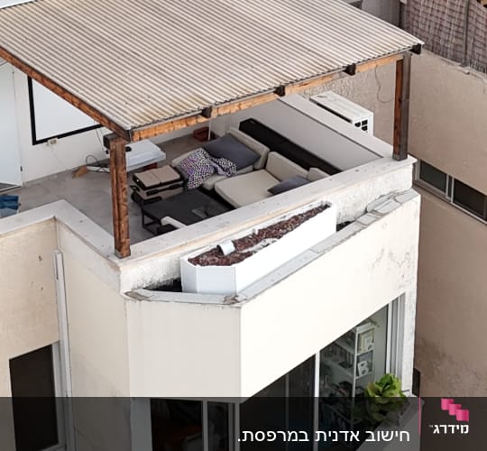 מרפסת עם ספה ומזגן על קיר חיצוני